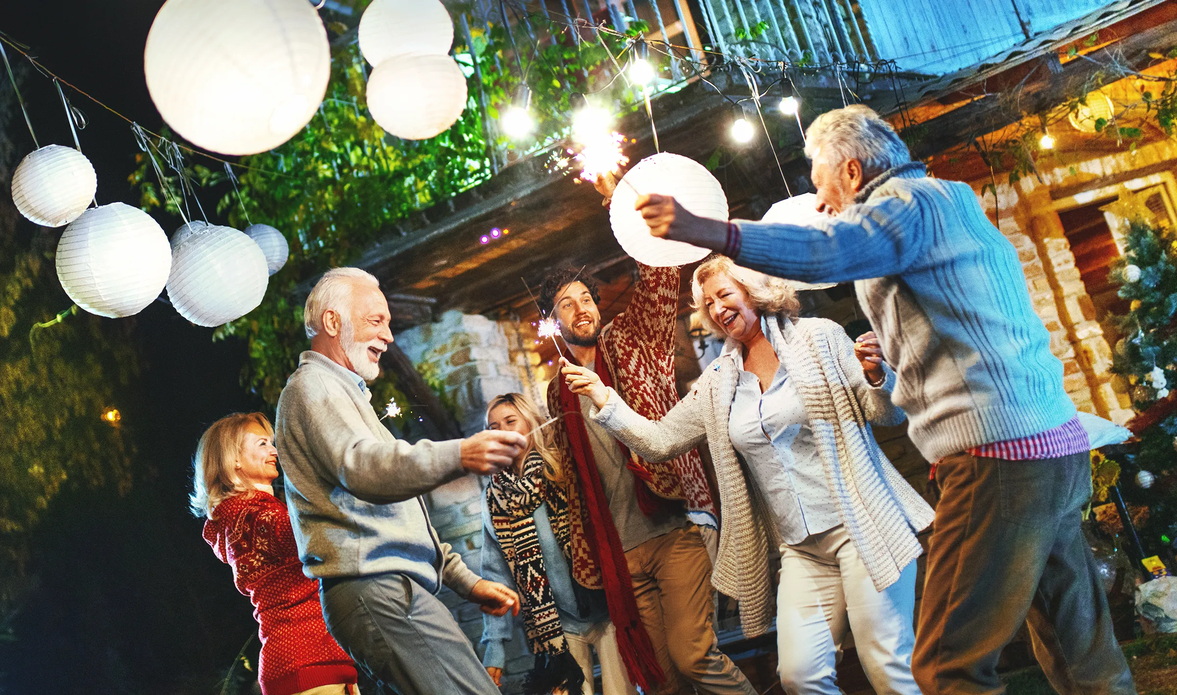 family dancing outside with sparklers at night