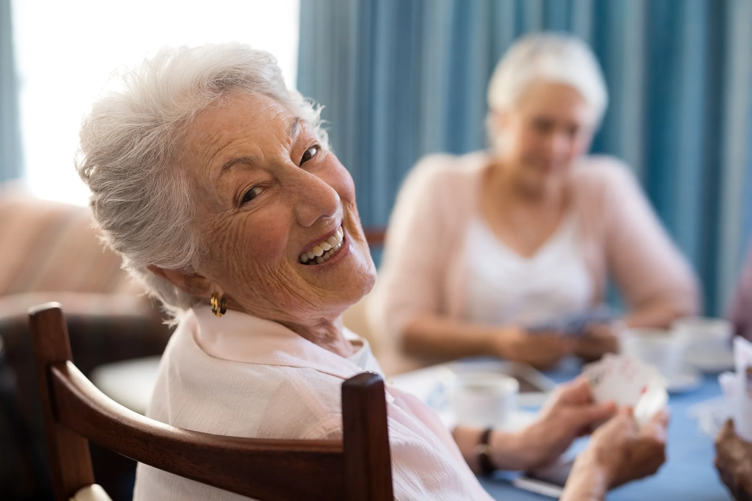 happy woman playing cards at memory care community