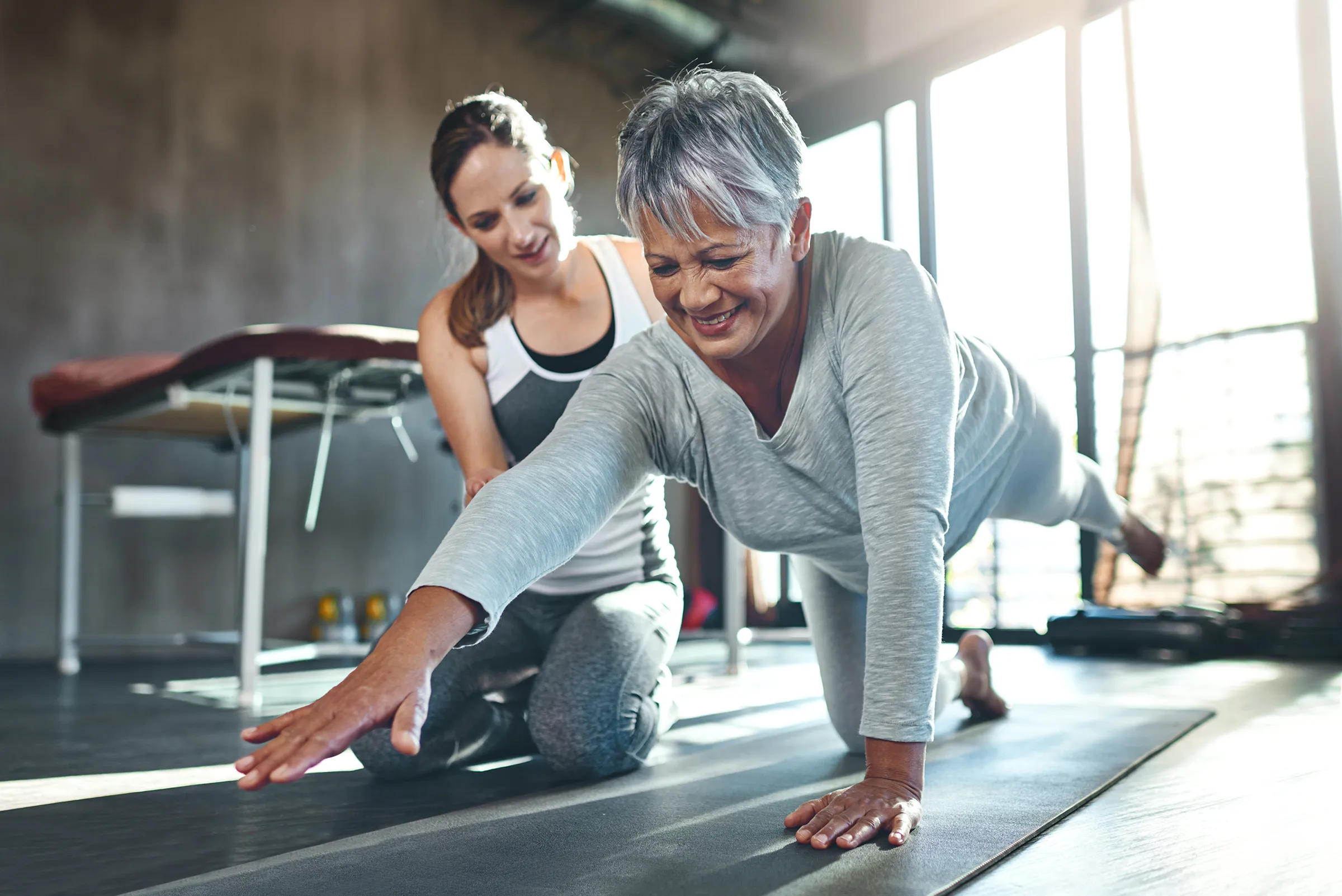 women with fitness trainer at assisted living community